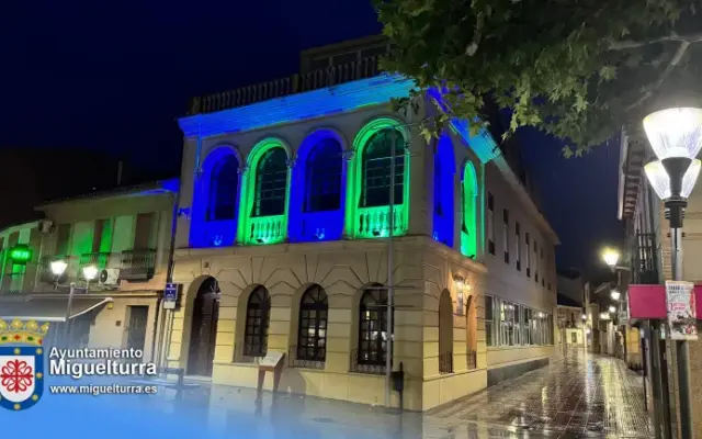 Fachada del Centro de Día de Miguelturra iluminada de azul y verde con motivo del Día de la Retina