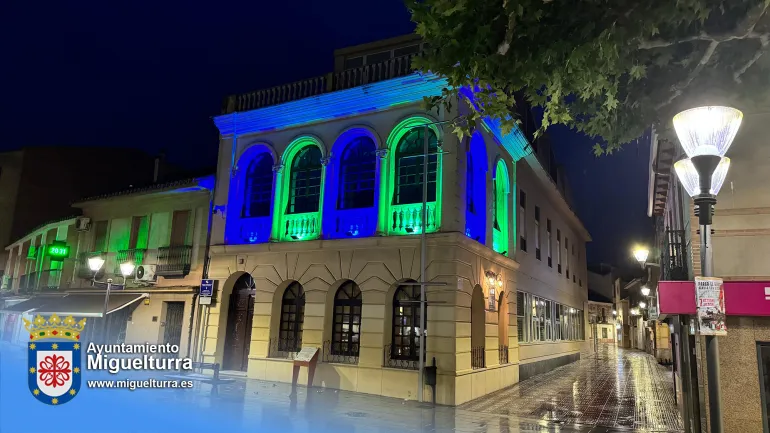 Fachada del Centro de Día de Miguelturra iluminada de azul y verde con motivo del Día de la Retina