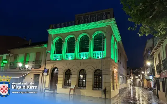 Fachada del Centro de Día de Miguelturra iluminada de verde con motivo del Día Mundial del Farmacéutico